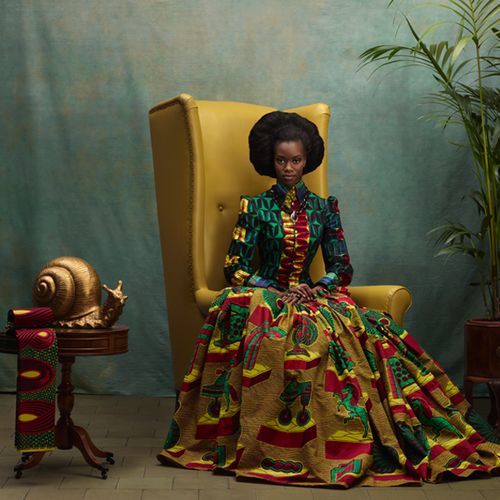 regal black woman sitting on large yellow chair