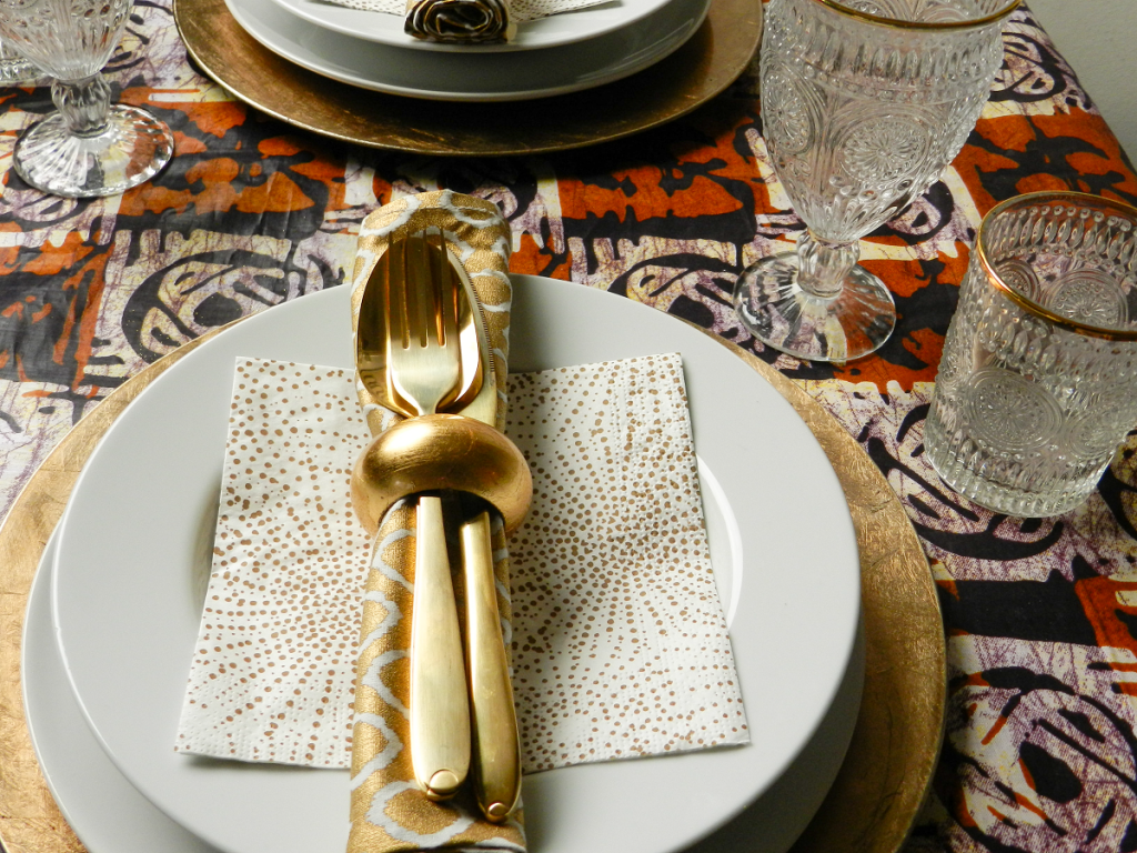 xmas table covered in brown and cream ankara fabric with gold and white accessories