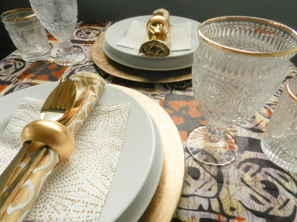 xmas table covered in brown and cream ankara fabric with gold and white accessories