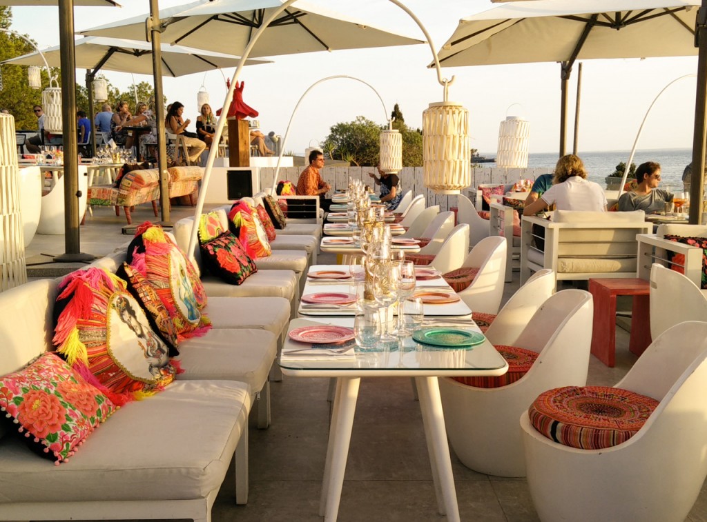 colourful rooftop seating area with colourful cushions and dinner plates